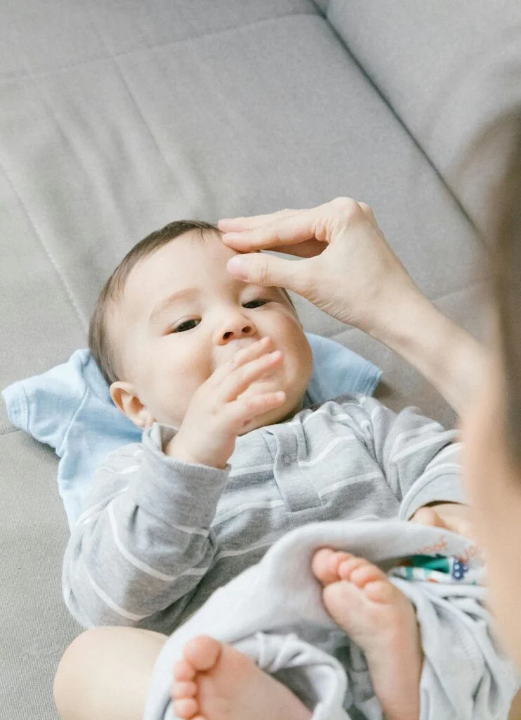 Baby playing with a mother's hand.