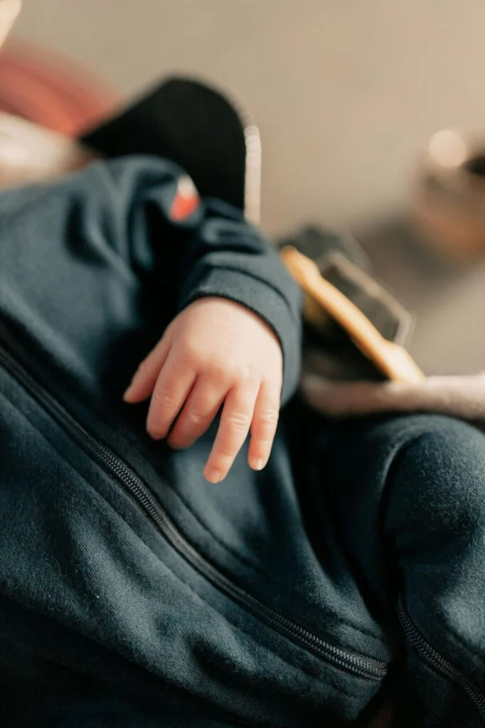 Infant hand resting on fabric.