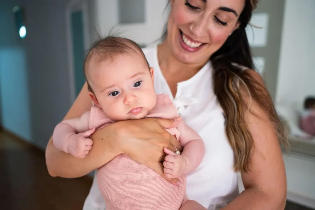 Mother holding her 5-month-old baby closely at home